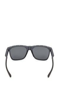 Black sunglasses with square lenses, a matte finish, and angular frames. Temple arms are sleek and slightly curved for a modern design.