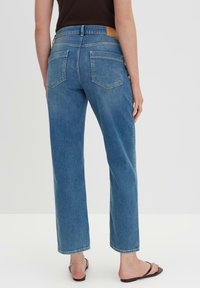 Blauwe denim jeans met een recht model, voorzien van een hoge taille, twee achterzakken en een getextureerde tan leren patch op de achterste tailleband.