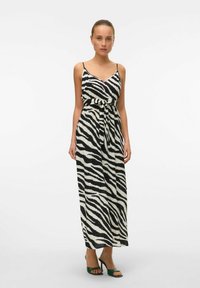 Robe maxi à rayures zèbres noir et blanc avec un bustier ajusté, des bretelles spaghetti réglables et un détail de taille nouée.