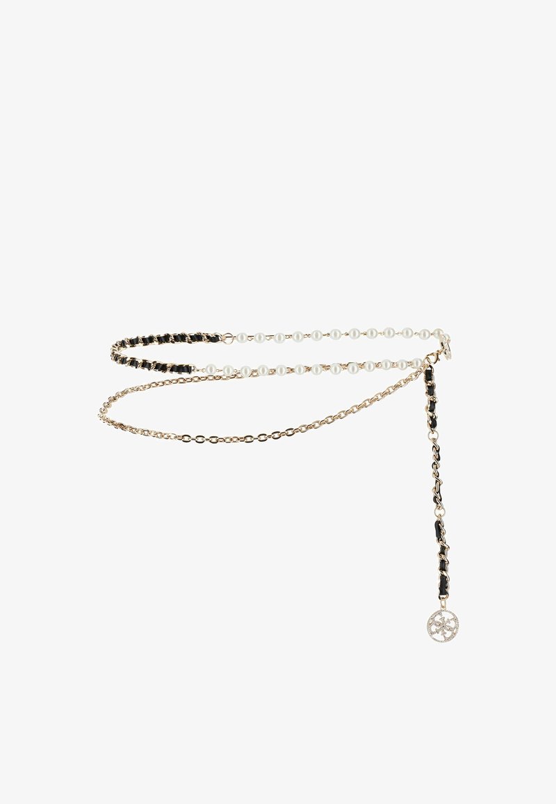 Ceinture chaîne ton or ornée d'une alternance de perles noires et blanches, avec un pendentif décoratif suspendu à une extrémité.