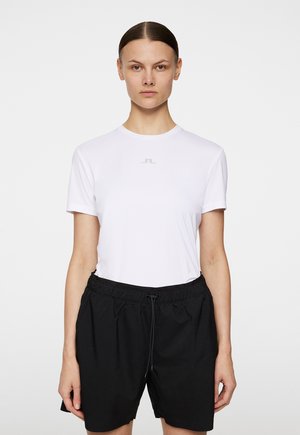 Hvid kortærmet T-shirt med rund hals og diskret grå logo, parret med sorte shorts med elastisk talje. Glat tekstur og enkelt design.