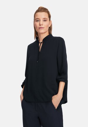 Black lightweight blouse with a high collar and tie detail, featuring long sleeves and a relaxed fit. Smooth texture and versatile design.