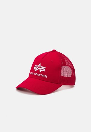 Gorra de béisbol roja con parte trasera de malla y logo y texto blancos de Alpha Industries en la parte delantera, mostrada sobre un fondo liso.