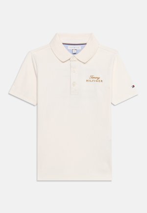 Koszulka polo w kolorze kremowym, z krótkim rękawem, kołnierzykiem, trzema guzikami, "Tommy Hilfiger" wyhaftowane na piersi złotą nicią oraz małym logo flagi na rękawie.