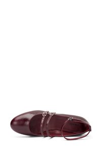Chaussure en cuir bordeaux avec un bout arrondi, deux sangles décoratives et une fine sangle de cheville. Texture lisse avec une finition brillante.