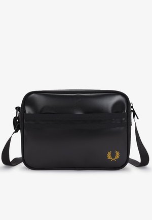 Sort rektangulær crossbody-taske med justerbar strop, lynlås, front horisontale striber og lille gyldent laurbærlogo nederst til højre.