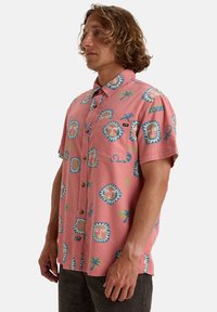 Korte mouw, knopenhemd in het roze, met tropische patronen in blauw, groen en beige, voorzien van een borstzak en een kraag.
