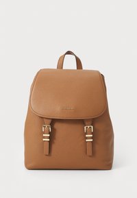 Sac à dos en cuir tan avec une surface texturée, un rabat avec deux accents de boucle en ton doré et une poignée supérieure pour le transport.