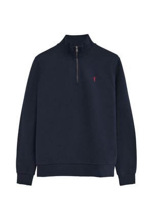 Granatowy sweter z długim rękawem, z suwakiem do 1/4 długości i małym czerwonym wyszywanym logo na lewej piersi. Ściągacze na mankietach i dole.