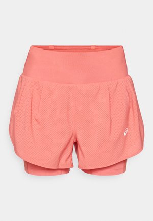 Shorts de sport roses avec une couche extérieure perforée et respirante et des shorts intérieurs ajustés. Design loose avec une taille large et un détail de marque.
