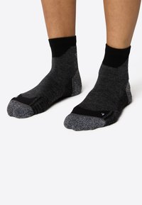 Czarne i ciemnoszare skarpetki do kostek o teksturowanym wykończeniu, z wzmocnionymi palcami i piętami oraz kontrastującymi czarnymi ściągaczami.