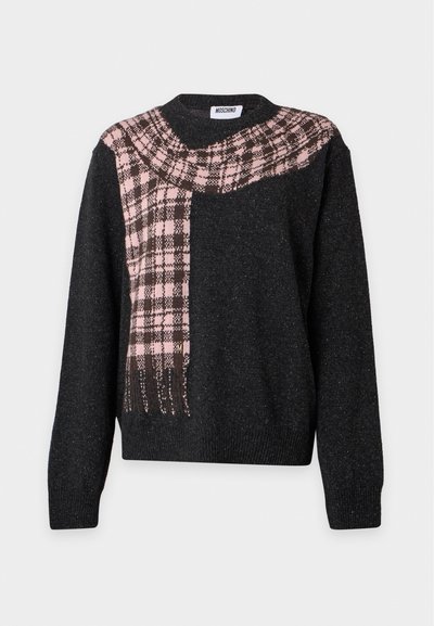 Pull noir à manches longues avec un motif d'écharpe à carreaux rose et marron drapé en diagonale sur la poitrine et l'épaule.