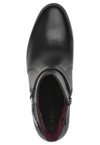 Bottine en cuir noir avec un bout arrondi, fermeture éclair sur le côté et doublure bordeaux. Texture lisse avec des accents matériels minimaux.