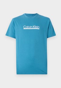 Tyrkysové tričko s krátkym rukávom vyrobené z bavlny, s bielym logom "Calvin Klein" na hrudníku a klasickým okrúhlym výstrihom.