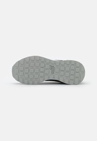 Soletta di sneaker Puma, in gomma grigia con un modello di trazione multi-direzionale e texturizzato. Design semplice, con logo.