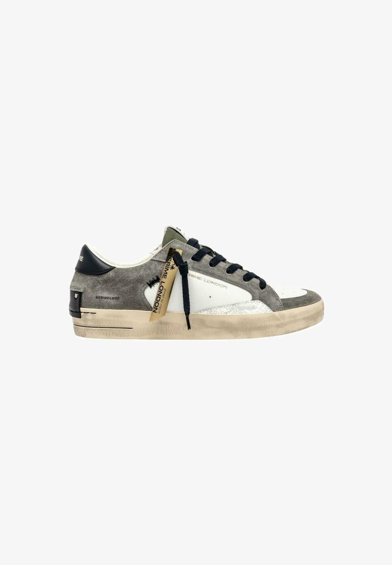 Sneaker basse in suede grigio e pelle bianca con lacci neri, suola beige e un'etichetta Prime London appesa sul lato.