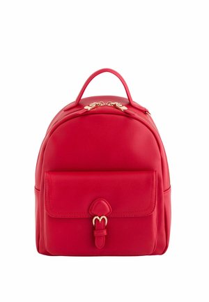 Petit sac à dos rouge avec une poche avant dotée d'une boucle et de tirettes zippées dorées sur fond blanc.