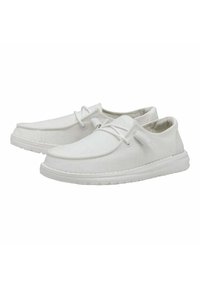 Scarpe da ginnastica bianche in tela con texture liscia, punta arrotondata e design minimalista. Presentano una chiusura con lacci e una suola ammortizzata.