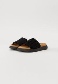 Sandali a infradito neri in suede con una larga fascia decorata da un accento metallic, soletta imbottita color beige e suola in gomma nera testurizzata.
