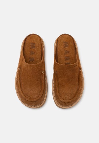 Rjave suknené slip-on čevlje z gladko teksturo, okroglo konico in šivanim okrasjem. Notranjost ima mehak podloženi material z vidnim logotipom.