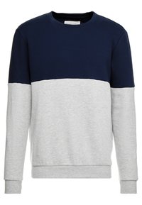 Sudadera de cuello redondo con una sección superior de color azul marino y una sección inferior de color gris claro. Está hecha de material de algodón suave y tiene un ajuste relajado.