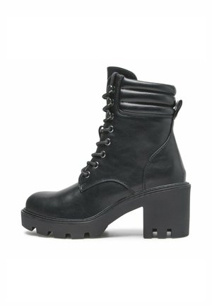 Schwarzer Lederknöchelstiefel mit klobigem Absatz, gepolstertem Kragen, vorderem Schnürverschluss und robust profilierter Sohle, seitlich auf weißem Hintergrund dargestellt.