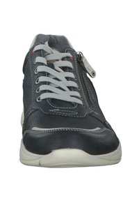 Zapatilla negra y gris con una parte superior de piel texturizada y malla, que presenta cordones grises y una cremallera lateral. Suela blanca con detalles de costura en contraste.