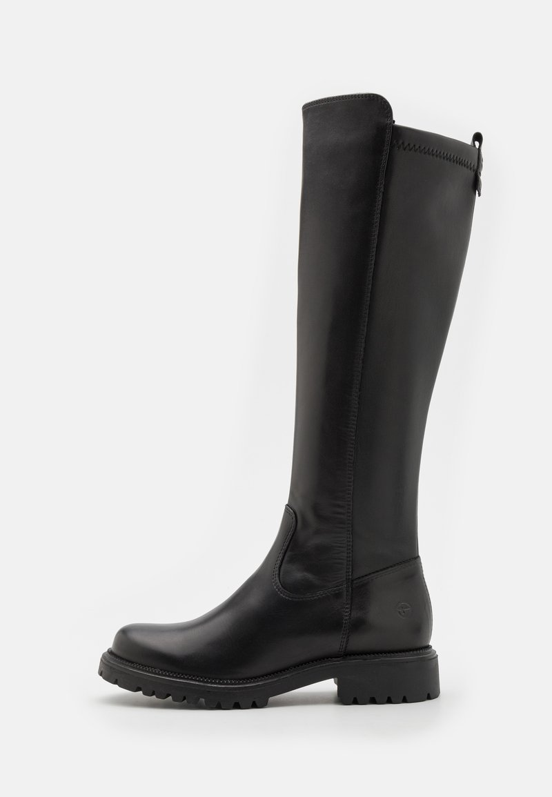 Bottes en cuir noir hautes avec une texture lisse, bout arrondi, semelle en caoutchouc robuste, et un détail de couture sur le côté. Accent de fermeture éclair en haut.