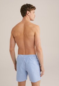 Kék és fehér csíkozott úszónadrág, elasztikus derékkal, hátsó zsebbel és laza szabással; a szövet könnyűnek és lélegzőnek tűnik.