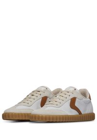 Brązowo-białe sneakersy z teksturowanej zamszowej cholewki, siateczkowymi panelami i żebrowaną gumową podeszwą. Posiadają haftowane logo na języku.