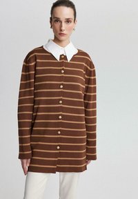 Bruine en beige gestreepte overhemd met een witte kraag, voorzien van lange mouwen en een relaxte pasvorm, gemaakt van zachte stof.