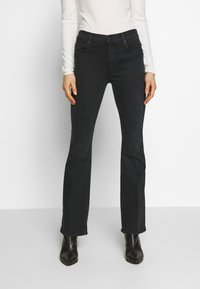 Svarta denimjeans med rak ben-design, femfickorsstil och en mjuk yta, kombinerade med svarta höga ankelstövlar.