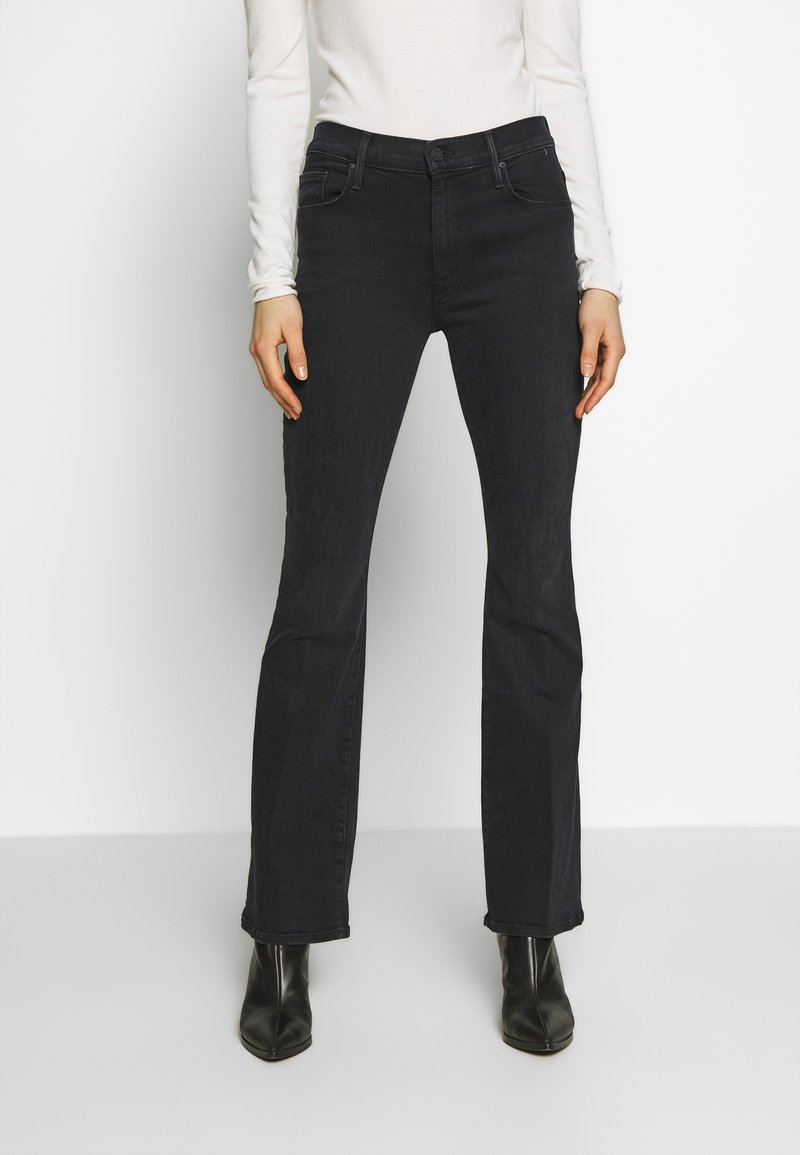 Svarta denimjeans med rak ben-design, femfickorsstil och en mjuk yta, kombinerade med svarta höga ankelstövlar.