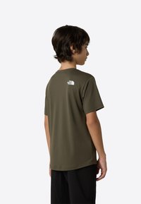 Olivo zelena majica s kratkimi rokavi iz gladkega blaga, z majhnim belim logotipom na zgornjem delu hrbta in sproščeno postavo.