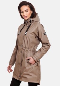 Water-resistant tan raincoat with a cinched waist, front pockets, adjustable hood, and contrasting drawstrings. Features snap-button closures.