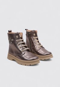 Bottines métalliques en bronze avec des accents floraux décoratifs, des œillets métalliques et des semelles en caoutchouc beige. Design à lacets avec une finition texturée.