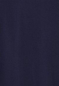 Marineblauer Stoff mit einem subtilen strukturierten Muster, das kleine Perforationen für Atmungsaktivität und ein glattes, leichtes Gefühl aufweist.