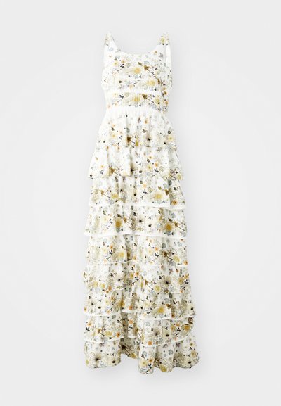 Maxi dress in tessuto leggero con sfondo bianco e motivi floreali gialli, viola e neri; le rouches stratificate aggiungono volume.