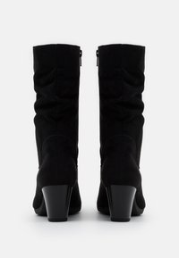 Bottes de cheville en faux suède noir avec un design plissé, bout rond et un talon carré de 6,5 cm. Présente une fermeture éclair discrète à l'arrière.