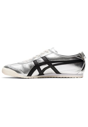 Lavprofileret sølv sneaker med sorte striber på siden, hvide snørebånd og en hvid sål.