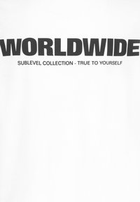 White cotton t-shirt featuring bold black text "WORLDWIDE" and smaller text "SUBLEVEL COLLECTION - TRUE TO YOURSELF" below.