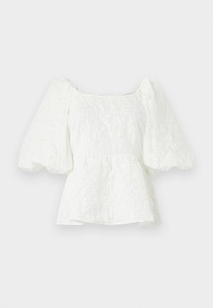 White, textured blouse with a square neckline and puffed sleeves. Features a peplum waist, showcasing a floral pattern throughout.