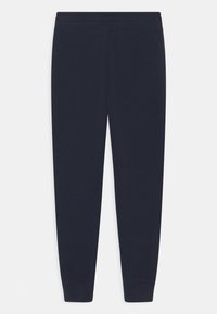 Marineblauwe joggingsbroek van zacht materiaal, met een elastische tailleband en taps toelopende benen met ribbels aan de enkels.
