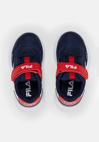 Sneakers blu navy con accenti rossi e una chiusura in Velcro, caratterizzati da una tomaia testurizzata, suola bianca e un logo Fila ben visibile.