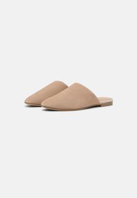 Beiga mockasiner i mocka med en slät yta och spetsig tå. Låg trähäl och minimalistisk design.