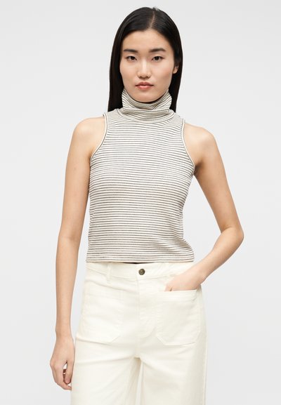 Haut sans manches à col roulé rayé crème et noir, en tissu doux, avec une silhouette ajustée et un design à col haut.