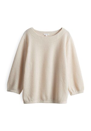 Pull en maille gaufrée, à manches longues, de couleur beige clair. Présente un large décolleté et des poignets froncés. Texture douce avec une coupe décontractée.