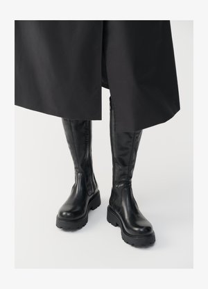 Czarne kozaki do kolan z gładką skórzaną teksturą, masywnymi podeszwami oraz bocznymi zamkami do łatwego zakładania. Elegancki i funkcjonalny design.
