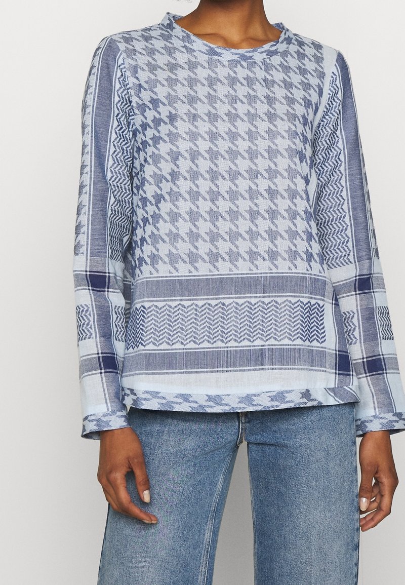 Chemise à manches longues à motif bleu avec des dessins en pied-de-poule et géométriques, dotée d'un col rond, réalisée en tissu léger.