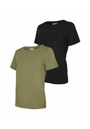 Femme enceinte debout, les mains sur le ventre, portant un t-shirt noir, un pantalon noir et des chaussures beiges sur un fond clair uni.